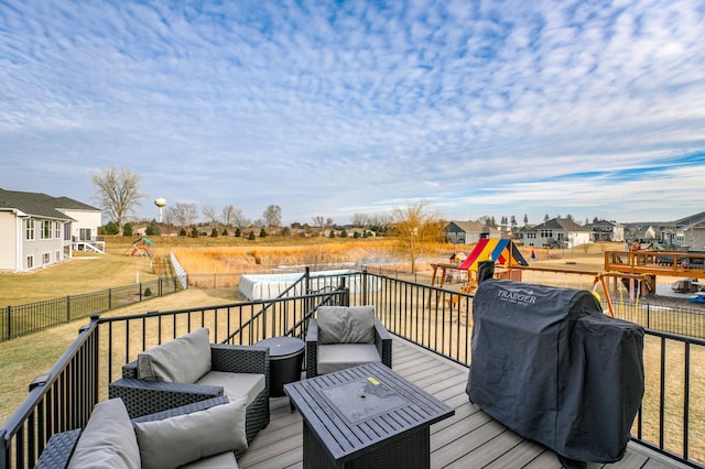 wooden deck with a playground, outdoor lounge area, and grilling area