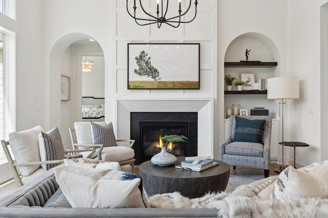 living room featuring built in features and a notable chandelier