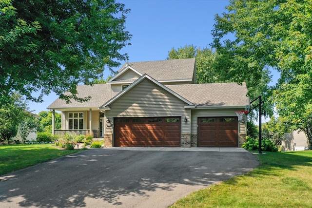 view of front of home with a front yard, a garage, driveway, and roof with shingles