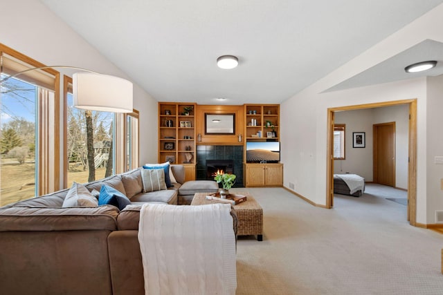 living room featuring baseboards, light carpet, a fireplace, and vaulted ceiling