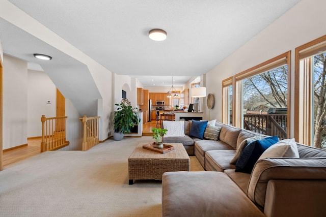 living room with light colored carpet, baseboards, and a notable chandelier