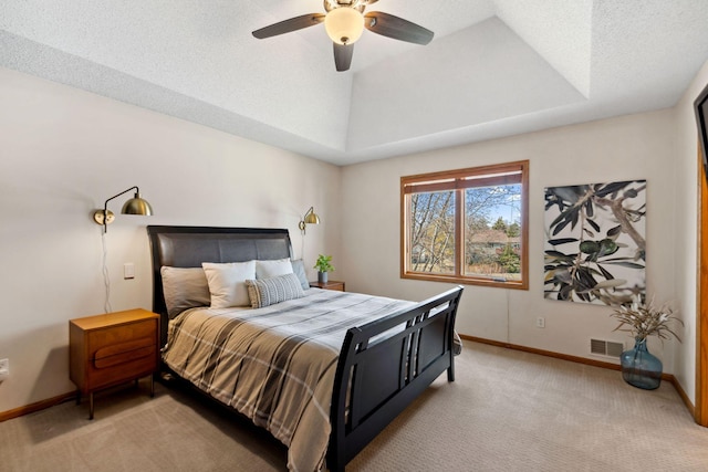 bedroom featuring a ceiling fan, visible vents, baseboards, a tray ceiling, and light colored carpet