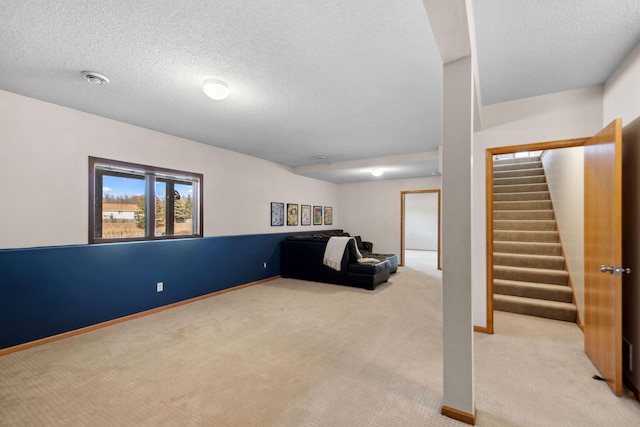 below grade area with a textured ceiling, stairway, baseboards, and light carpet