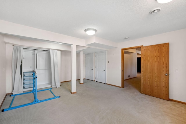 below grade area featuring baseboards, a textured ceiling, and carpet flooring