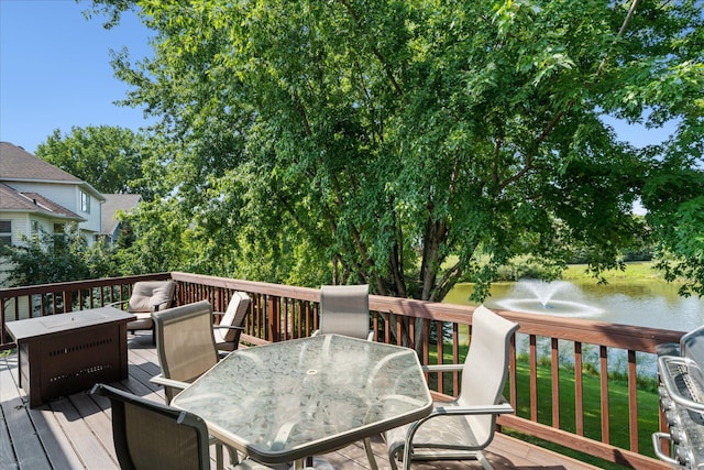 wooden terrace with outdoor dining area and a water view