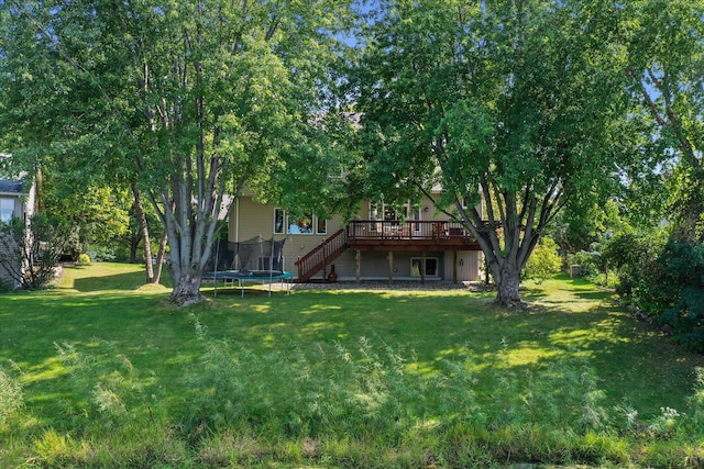 view of yard featuring a deck, stairs, and a trampoline