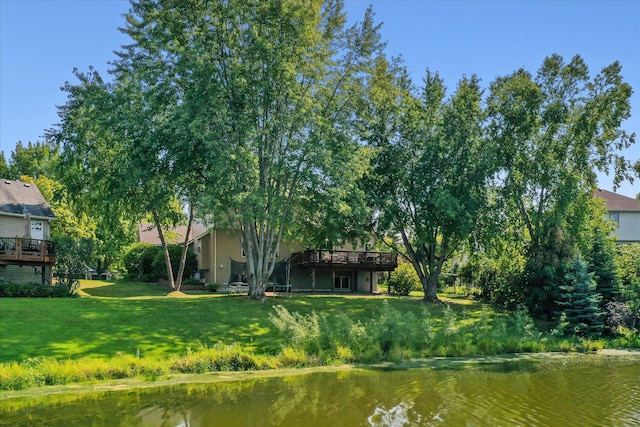 exterior space with a deck with water view and a yard