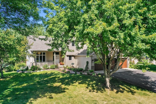 split level home featuring a front lawn, a porch, roof with shingles, a garage, and driveway