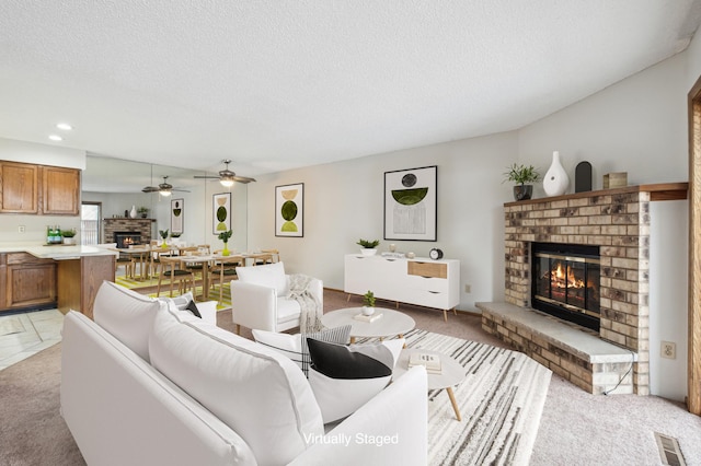 carpeted living room with a brick fireplace and a textured ceiling