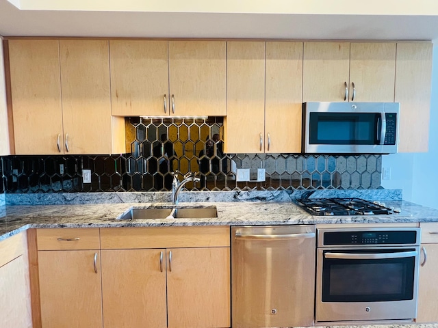 kitchen featuring tasteful backsplash, light brown cabinetry, sink, and appliances with stainless steel finishes