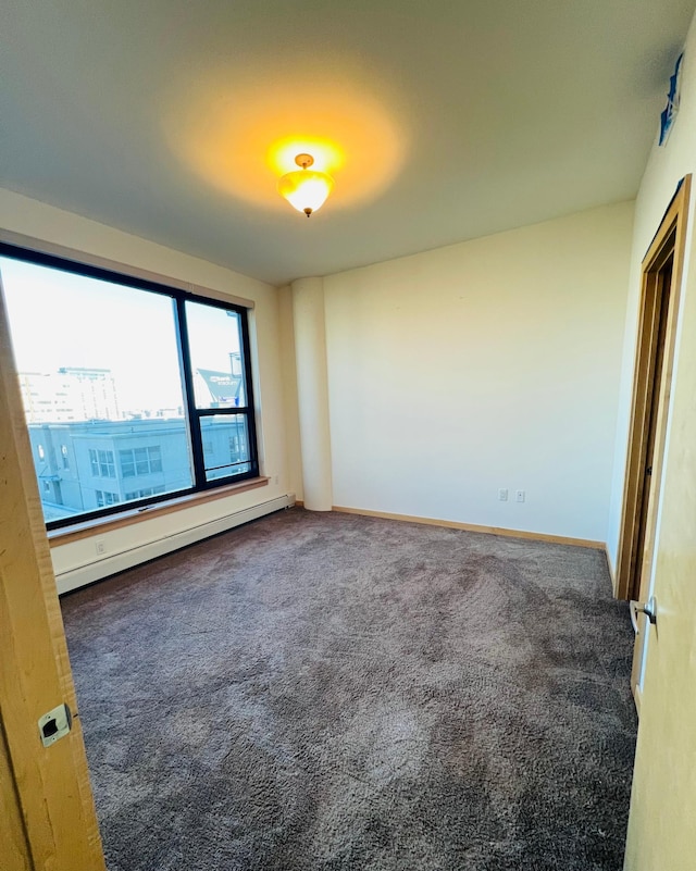 carpeted empty room with a baseboard radiator