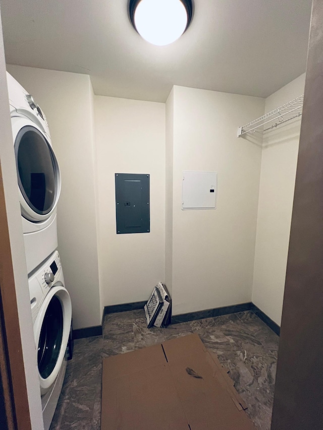 washroom with stacked washer / drying machine and electric panel