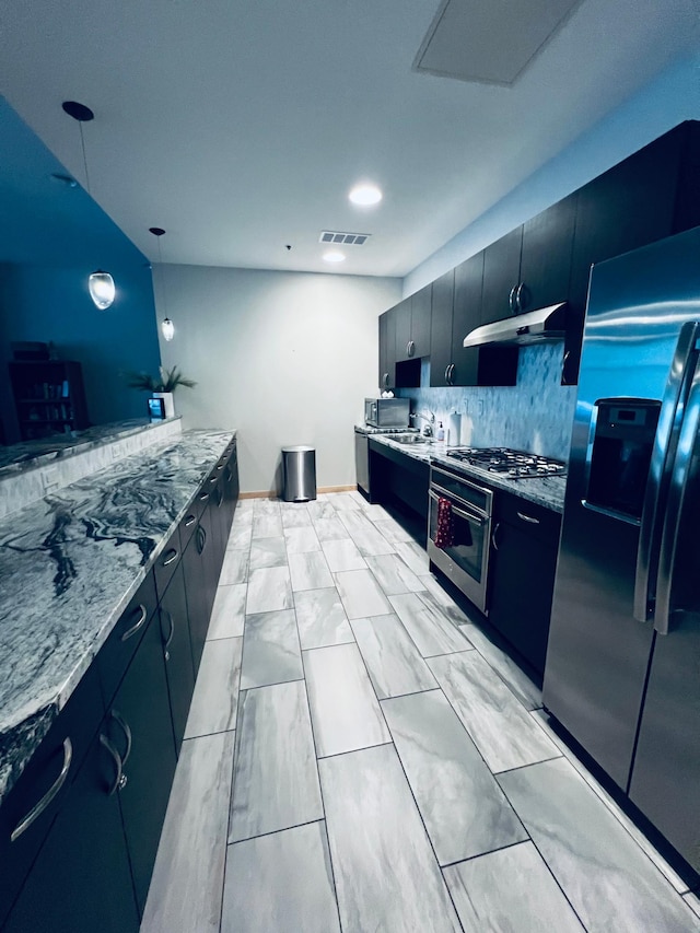 kitchen featuring tasteful backsplash, hanging light fixtures, stainless steel appliances, and sink