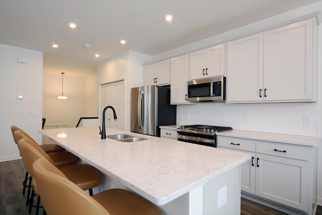 kitchen featuring sink, white cabinetry, a center island with sink, and stainless steel appliances