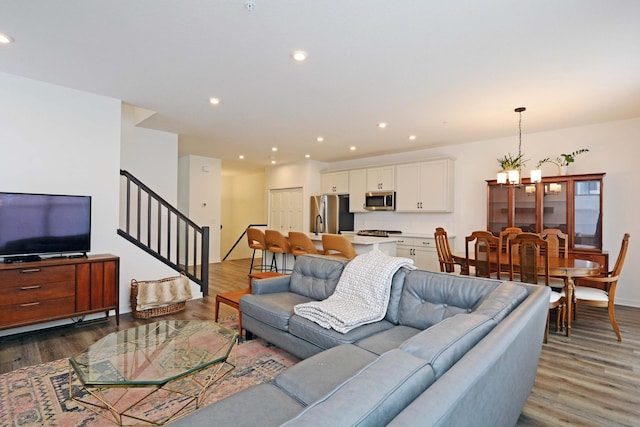 living room featuring an inviting chandelier and dark hardwood / wood-style floors