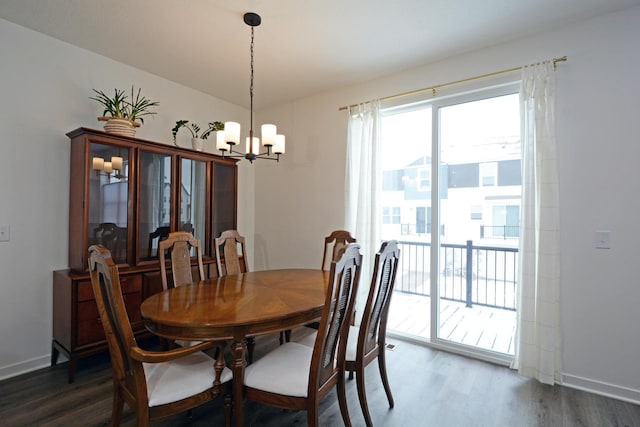 dining area with dark hardwood / wood-style floors and a notable chandelier