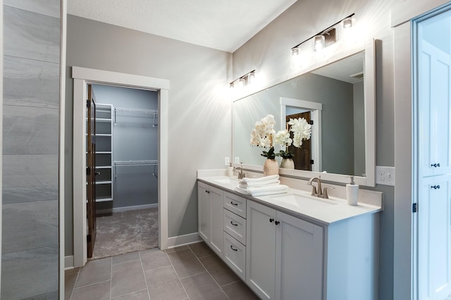 bathroom featuring a textured ceiling, tile patterned flooring, and vanity