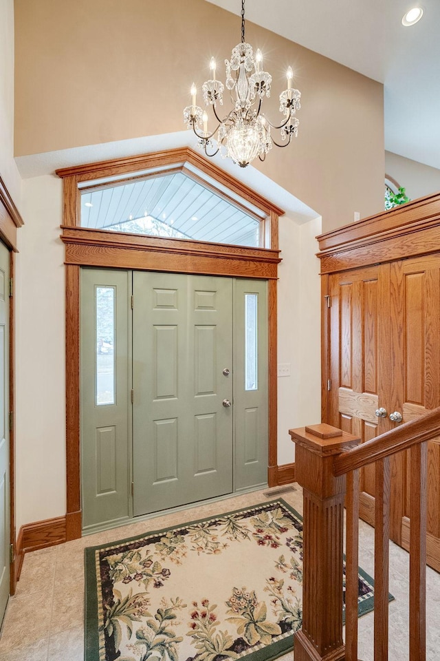 foyer with light tile patterned floors, vaulted ceiling, and a notable chandelier