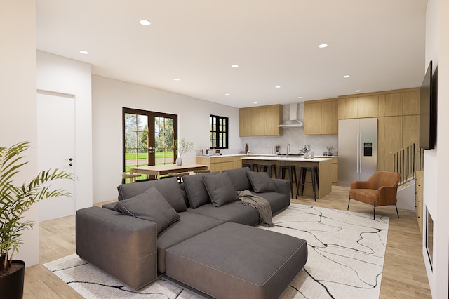 living room featuring light hardwood / wood-style floors, sink, and french doors