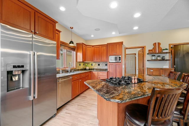4167 Hallgren Ln, Excelsior, MN 55331 - kitchen with appliances with stainless steel finishes, a sink, a center island, light wood finished floors, and a breakfast bar area