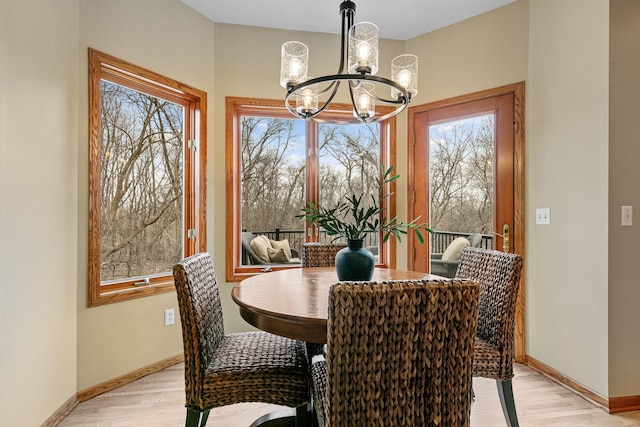 4167 Hallgren Ln, Excelsior, MN 55331 - dining room featuring a chandelier, baseboards, plenty of natural light, and light wood finished floors