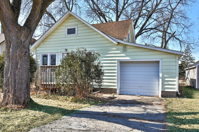 view of front of home featuring driveway and roof with shingles