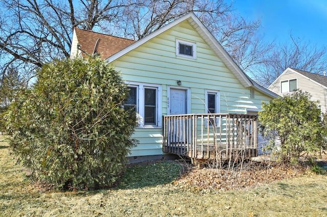 rear view of property featuring roof with shingles and a wooden deck