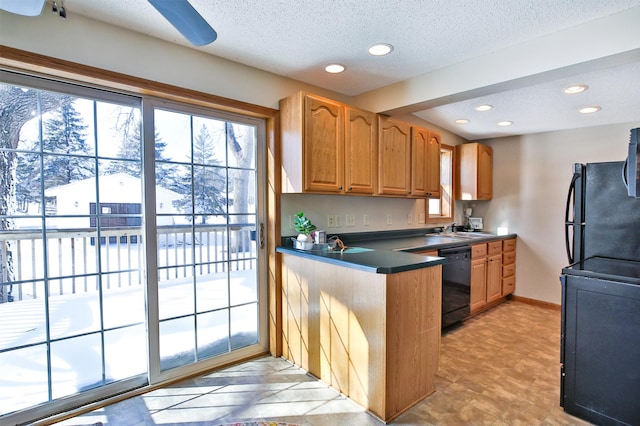 kitchen featuring a textured ceiling, black appliances, dark countertops, and a sink