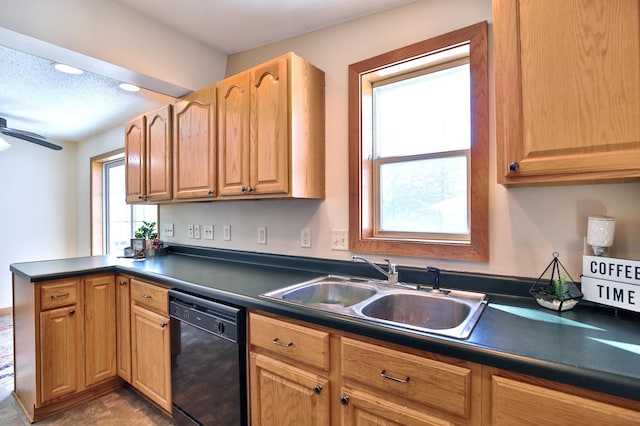 kitchen with dark countertops, a ceiling fan, a sink, dishwasher, and a peninsula