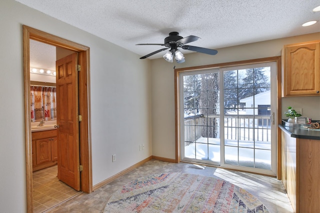 entryway with visible vents, ceiling fan, a textured ceiling, and baseboards