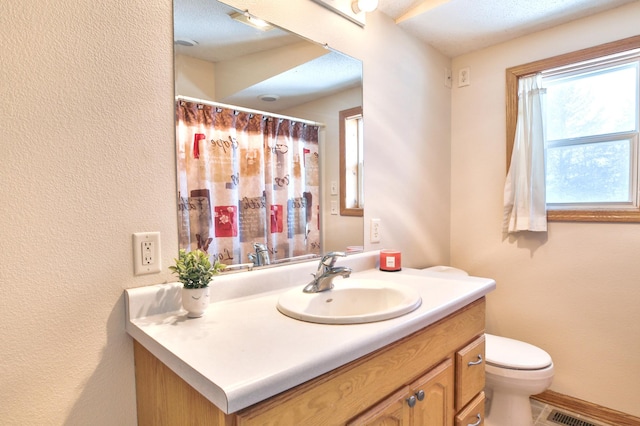 bathroom featuring visible vents, baseboards, a shower with shower curtain, toilet, and vanity