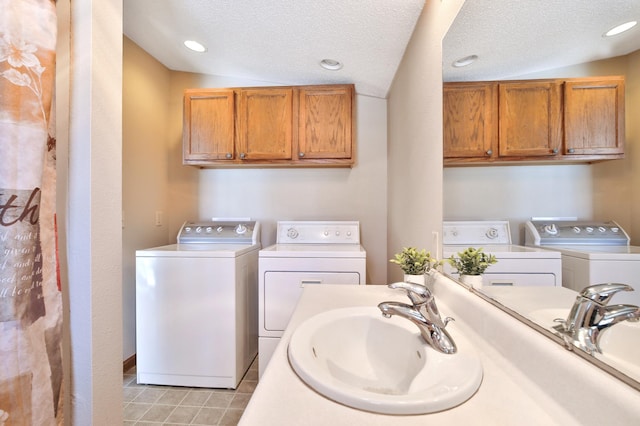 laundry area featuring laundry area, independent washer and dryer, a sink, and light tile patterned floors