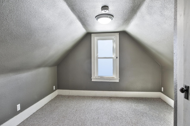 bonus room with carpet, baseboards, lofted ceiling, and a textured ceiling