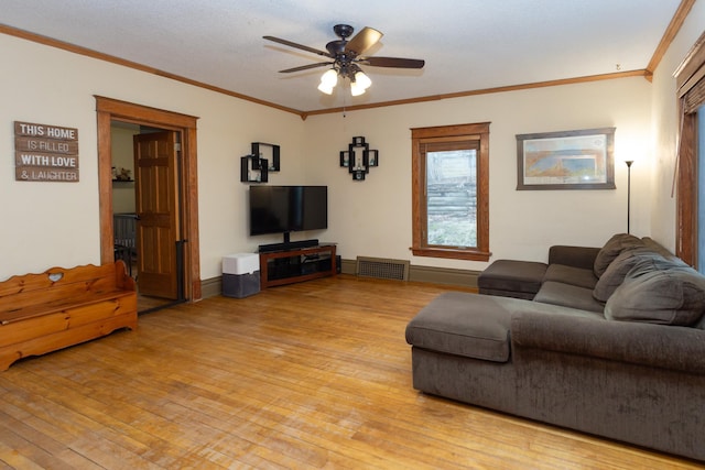 living room featuring visible vents, light wood-style floors, ornamental molding, and a ceiling fan