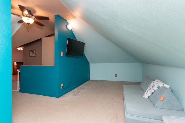 bonus room with carpet flooring, a textured ceiling, lofted ceiling, and a ceiling fan