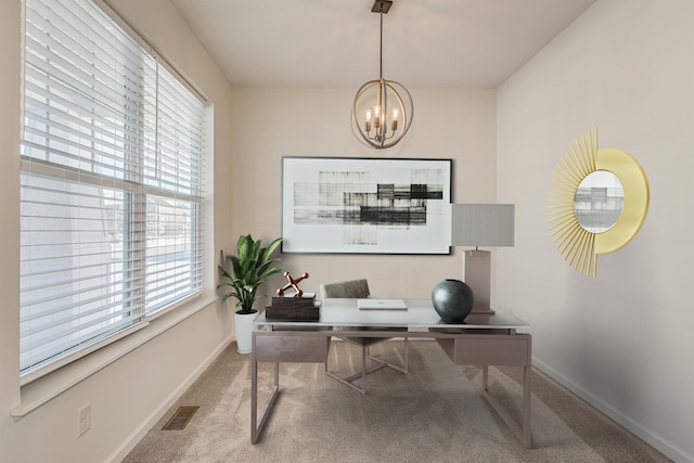 carpeted office with a notable chandelier and a wealth of natural light