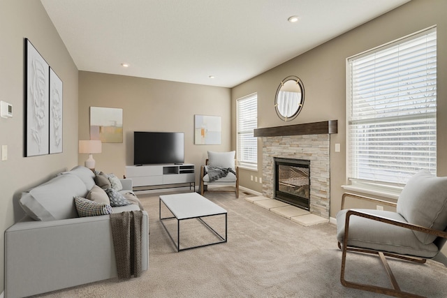 living room featuring light colored carpet and a stone fireplace