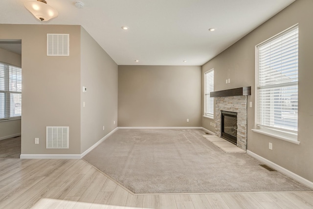 unfurnished living room with a fireplace and light hardwood / wood-style floors