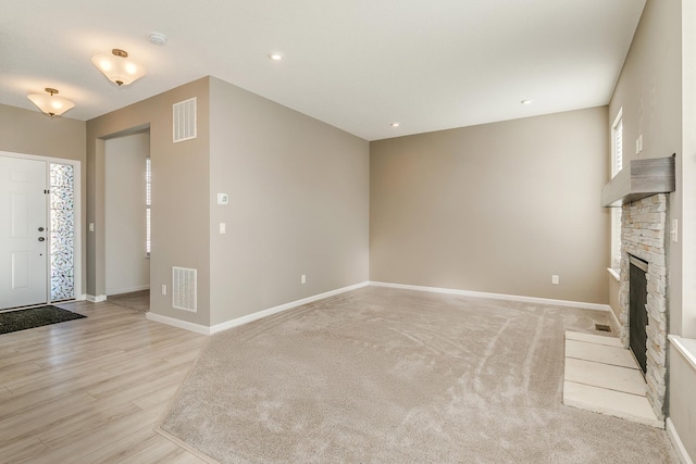 unfurnished living room featuring a fireplace and light wood-type flooring