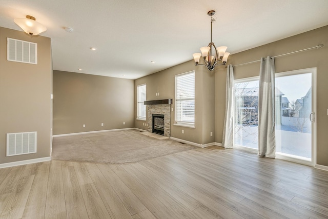 unfurnished living room with a fireplace, light hardwood / wood-style flooring, and plenty of natural light