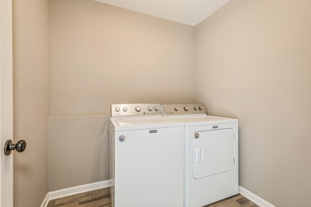 laundry room featuring washer and clothes dryer, a textured ceiling, and hardwood / wood-style floors