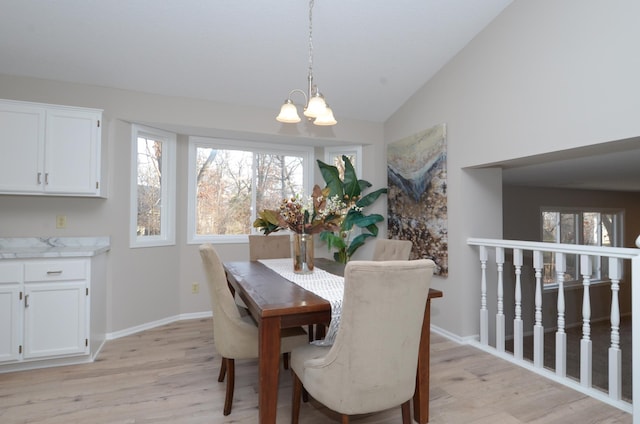 dining room featuring light hardwood / wood-style flooring, a chandelier, and vaulted ceiling