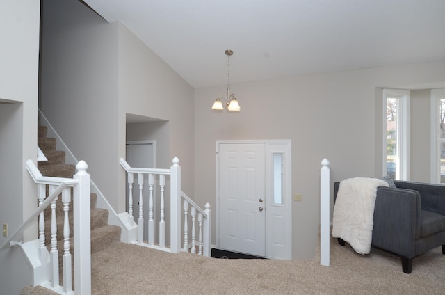 carpeted entryway featuring vaulted ceiling and an inviting chandelier