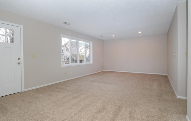 carpeted foyer entrance with a textured ceiling