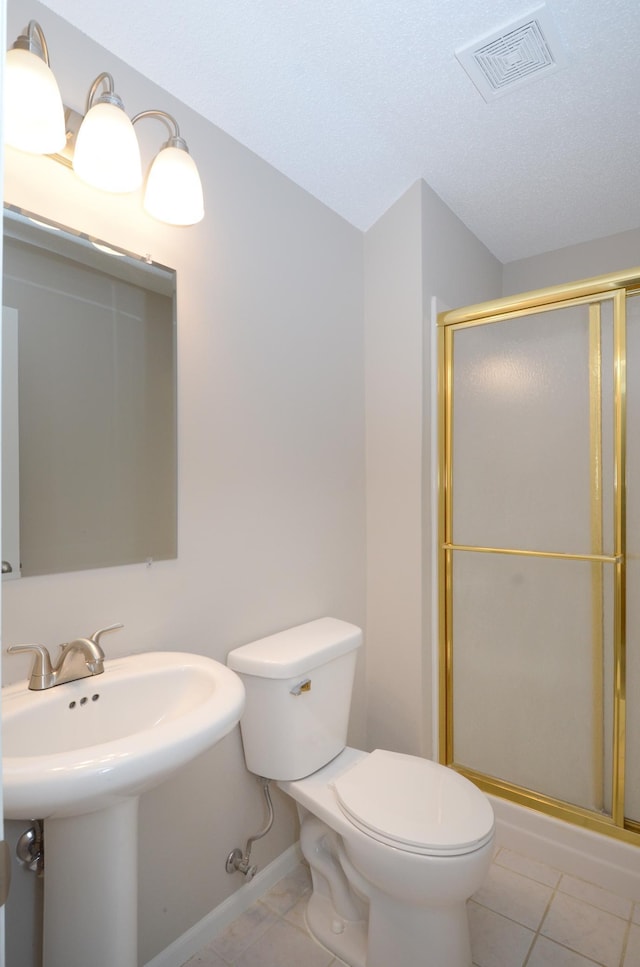 bathroom with tile patterned floors, toilet, an enclosed shower, and sink