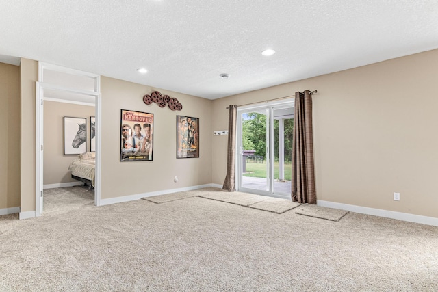 unfurnished room with carpet flooring and a textured ceiling