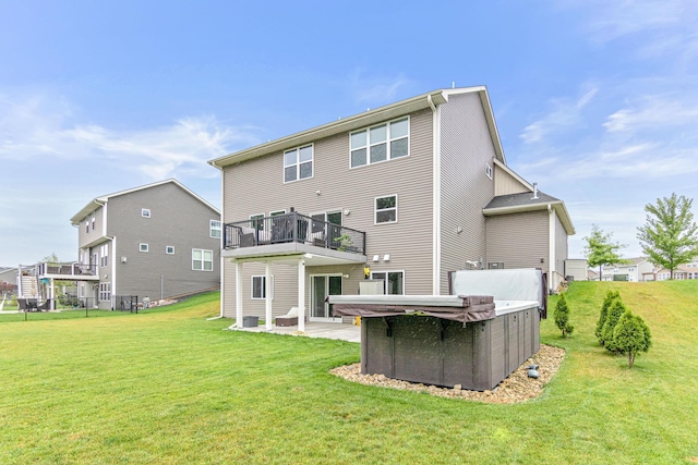 back of property featuring a yard, a balcony, and a patio area