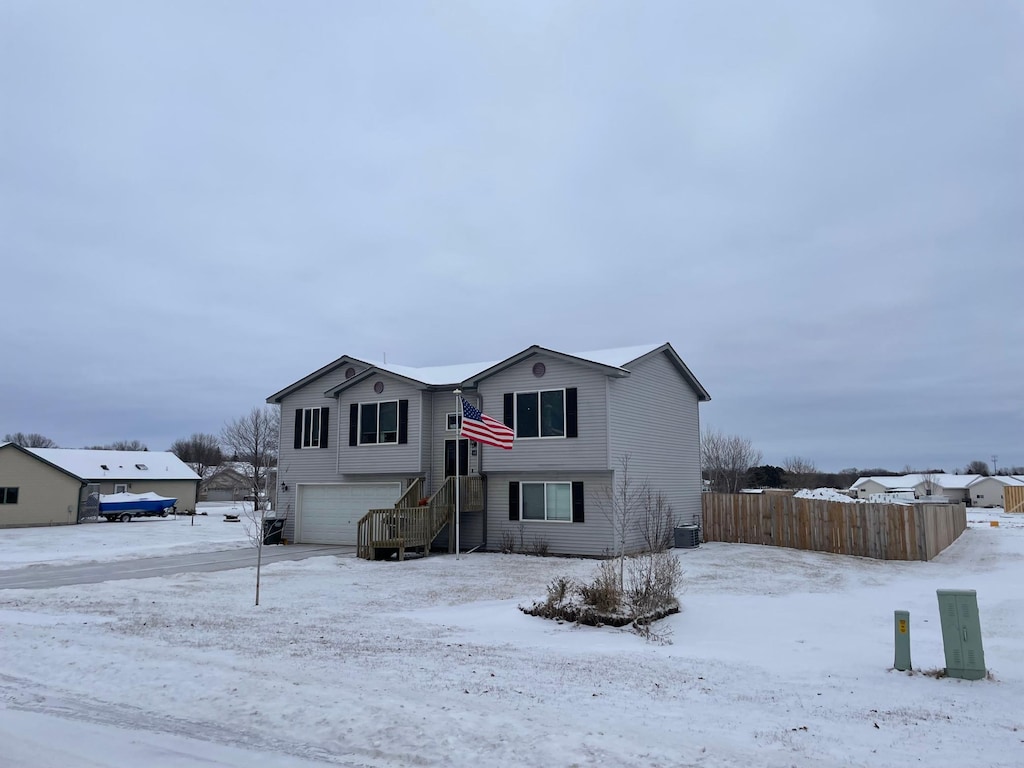 view of front of property featuring a garage and central AC