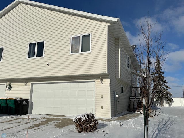 view of snowy exterior featuring a garage