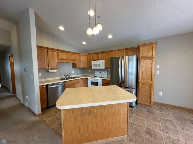 kitchen featuring appliances with stainless steel finishes, a center island, decorative light fixtures, lofted ceiling, and sink